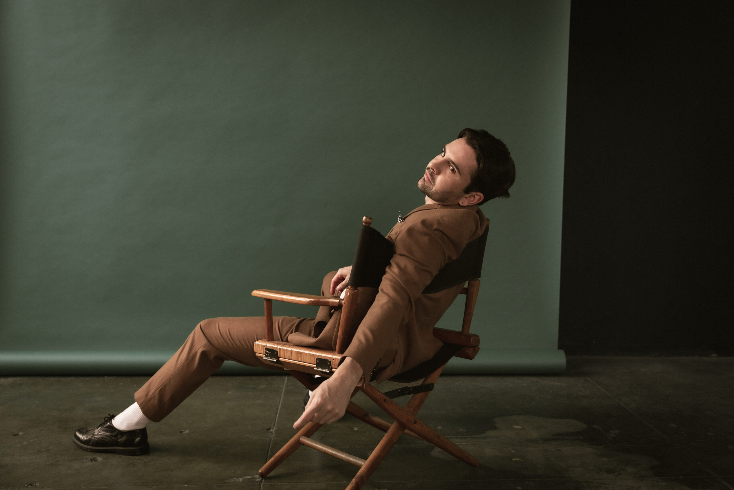 Actor Connor Delves reclining in a chair