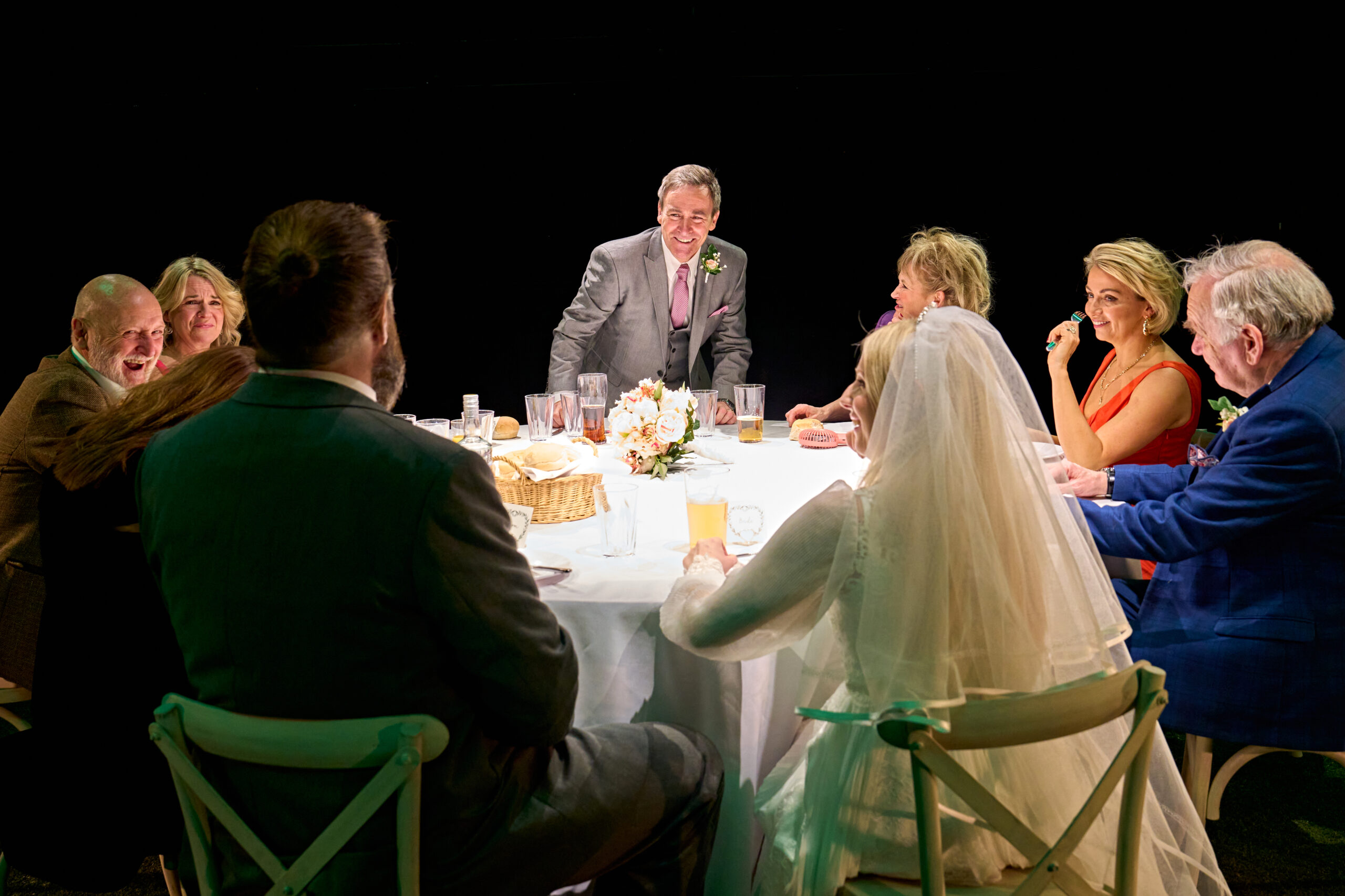 The cast sitting around a table eating at a wedding in 'Till the Stars Come Down'