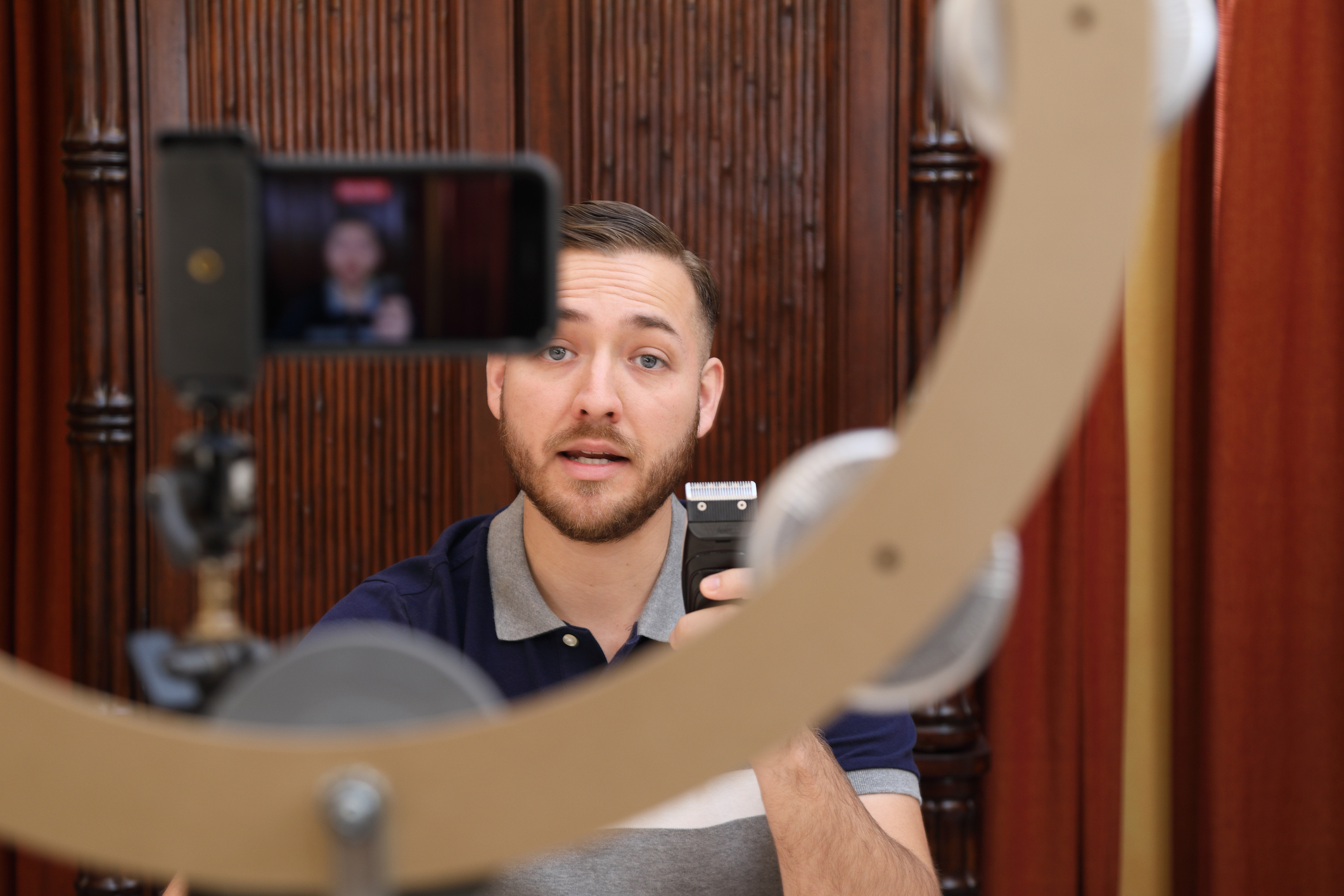 Male actor looking towards his phone, which is on a stand, whilst filming a self-tape
