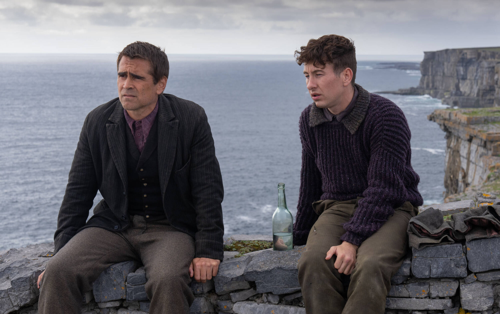 Colin Farrell and Barry Keoghan sitting on a wall overlooking the sea in 'The Banshees of Inisherin'