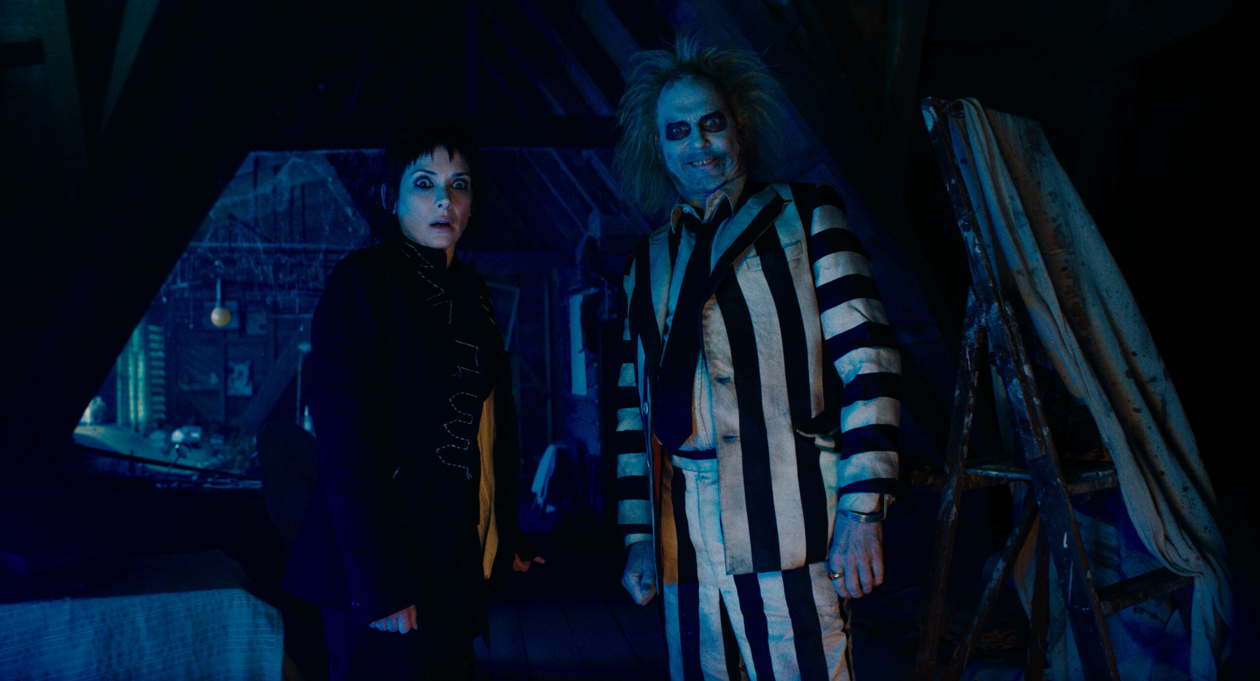 Lydia and Beetlejuice standing in a dark attic together in 'Beetlejuice Beetlejuice'