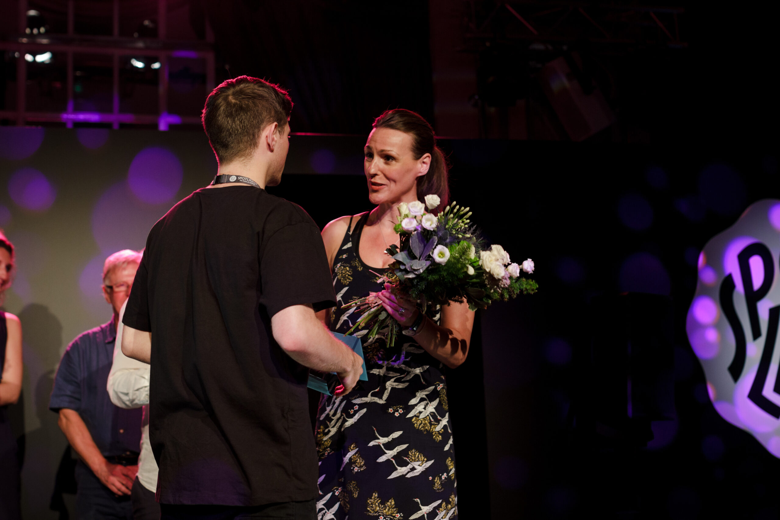 A woman giving a performer some flowers.