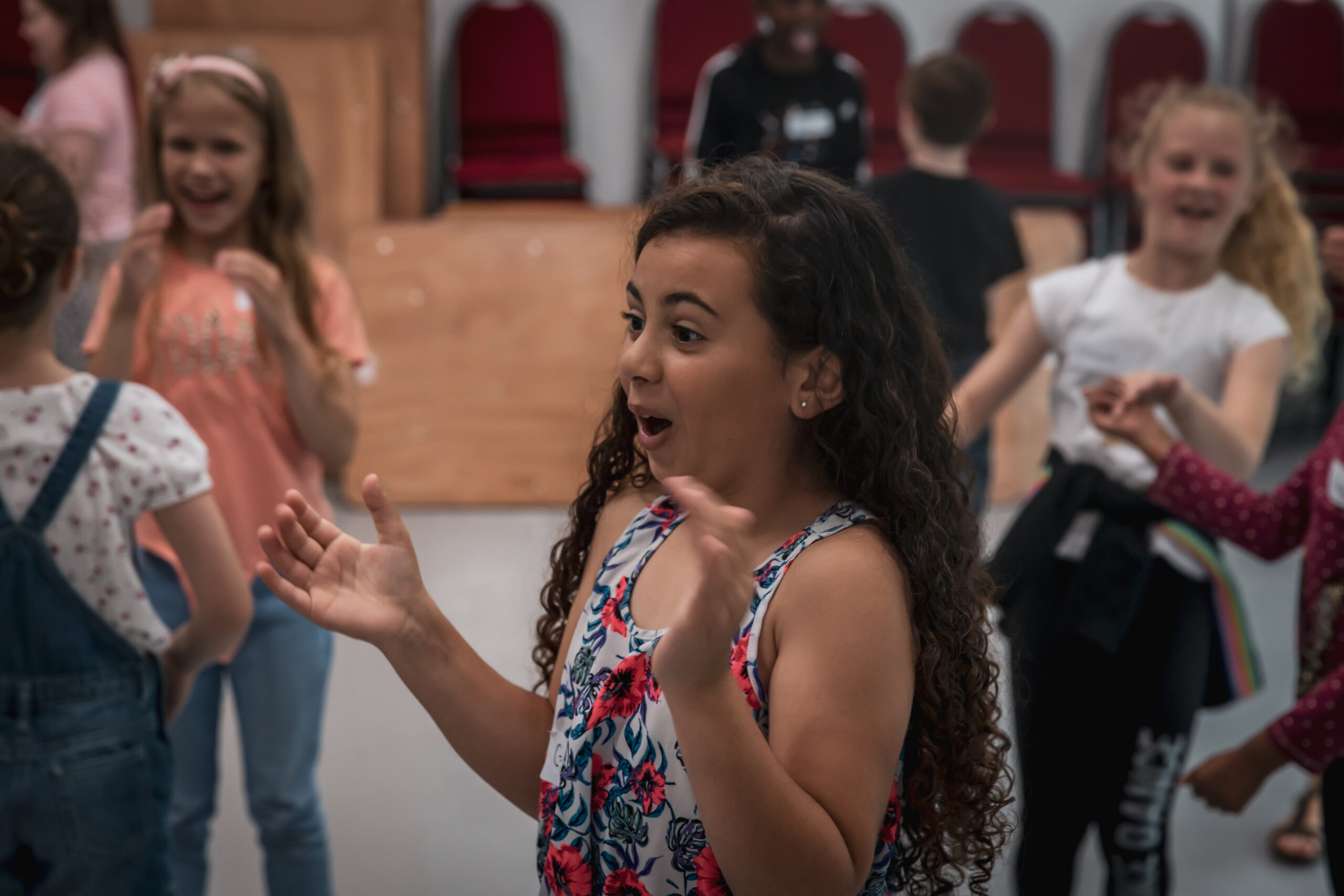 An excited young actor clapping her hands